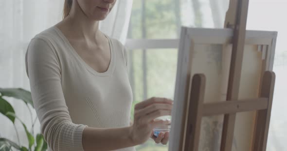 Artist mixing acrilic paint in a cup