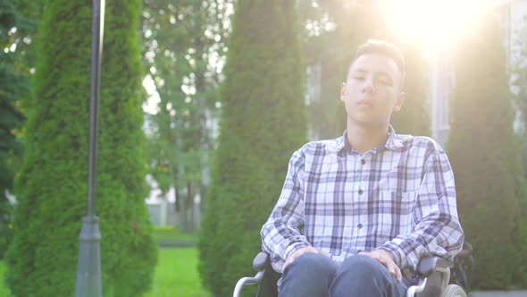 Portrait Young Asian Man Disabled in Wheelchair in Park