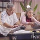 old asian senior couple packing cloth and stuff for a trip together - VideoHive Item for Sale