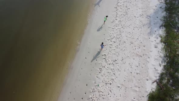 Aerial view from a drone of a happy Asian family of mother and daughters having fun playing
