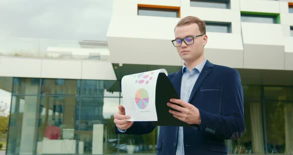 A Businessman is Looking Through Working Documents