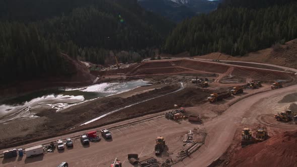 Aerial view flying over construction worksite at lake