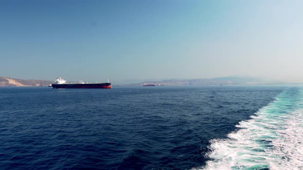 Wide shot of Argosaronikos sea at Greece, taken from ferry boat traveling, tanker ships in the frame
