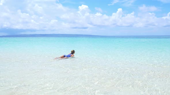 Woman sunbathing walking in turquoise water white sand beach tropical sea