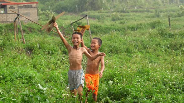 Poverty Boys  Playing With A Cardboard Airplane In Rain