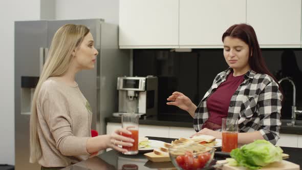 Women eating sandwiches and drinking juice