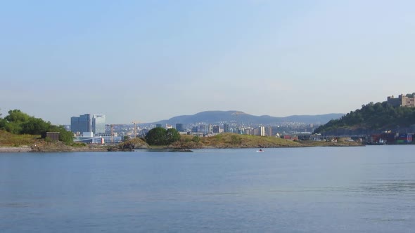 View froming boat that passes a man in a kayak on a sunny morning