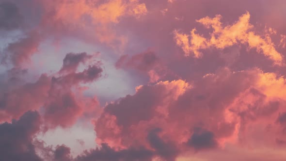 Cloudy sky with moving evening gold orange pink clouds. Beautiful Sunset or Sunrise