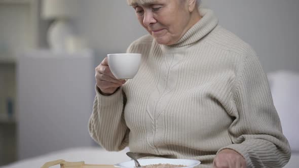 Crying Elderly Woman Drinking Tea at Nursing House, Loneliness in Old Age