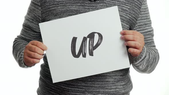 A person holding a sign with the message and the word "up"