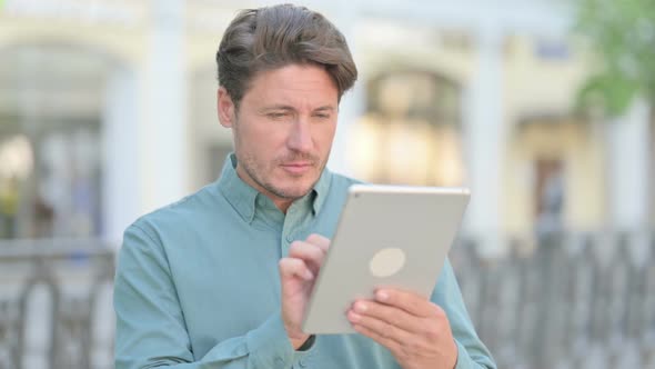 Outdoor Middle Aged Man using Tablet Outdoor