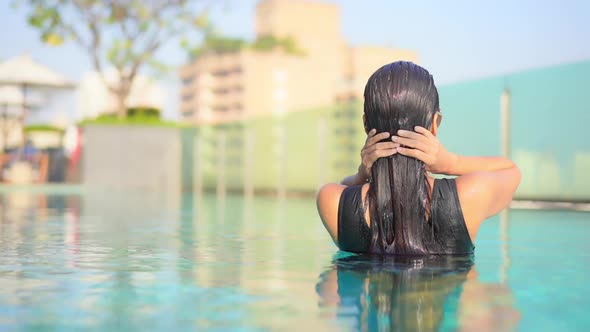 Young asian woman enjoy around outdoor swimming pool for leisure