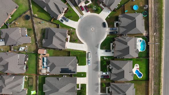 Top down aerial of rooftops of homes and swimming pools in modern American residential suburban comm