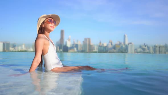 Young asian woman enjoy around outdoor swimming pool for leisure