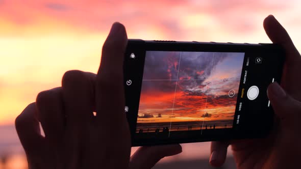 Female Hands Holding Smartphone and Doing Nature Photography. Young Tourist Woman Taking Photos