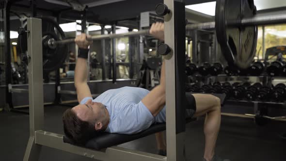 Close up image of man doing bench press at the gym.