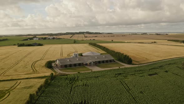 Large House in the Middle of the Farm Fields and Beautiful Clouds in Background