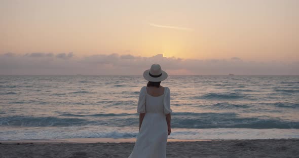 Attractive woman by the sea at sunset, slow motion. Shot on Black Magic Camera