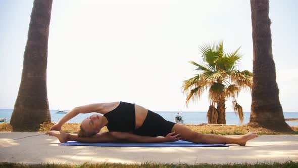 Gymnastics By the Sea  a Blonde Woman Sitting on the Splits and Bending to the Sides