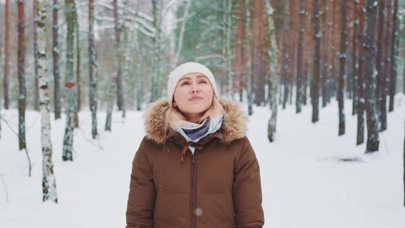 Pretty Woman in Winter Walking in the Forest and Admiring the Nature