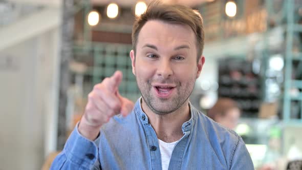 Portrait of Happy Casual Man Pointing with Finger 