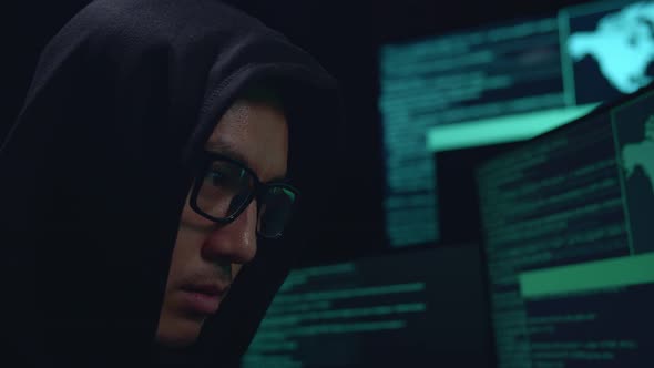 Close Up Hacker Face Hacking With Code On Multiple Computer Screens