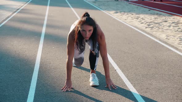 Top View of a Young Female Athlete Getting Ready for the Race on a Running Track