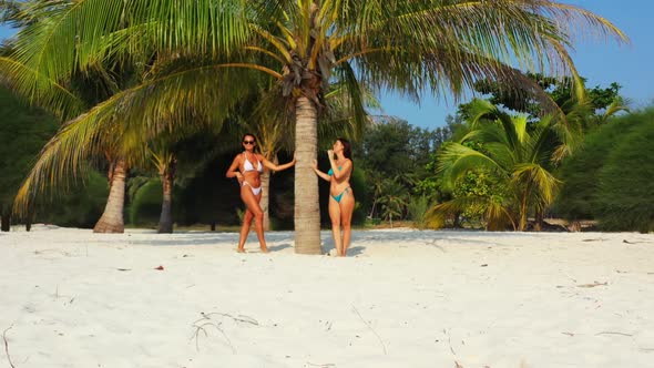 Beautiful women happy together on relaxing bay beach journey by turquoise sea with clean sandy backg