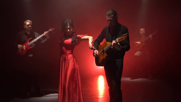 Dancer Performs Movements with Her Hands To the Music on the Guitar. Light From Behind. Smoke