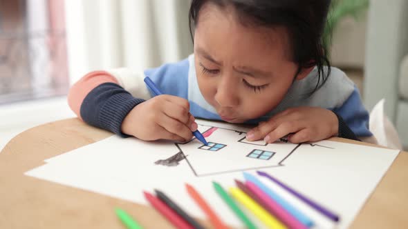 Asian Young Child Boy Drawing with Crayons Indoor at Home