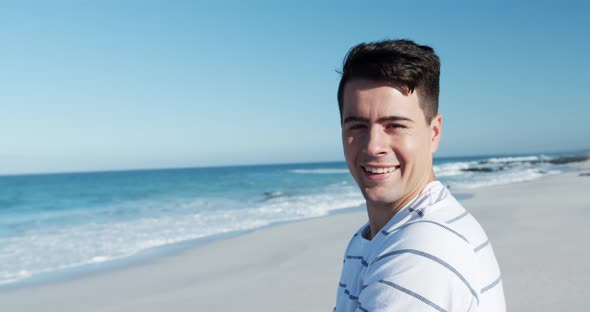 Man standing on the beach and looking at camera