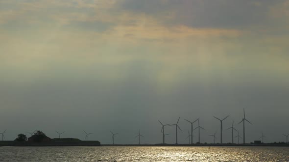 Windmills on the River Bank at Sunset