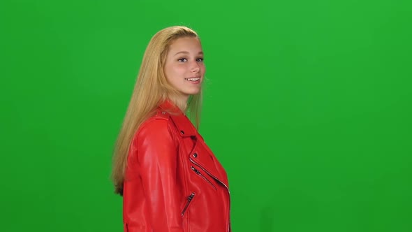 Portrait of Blonde Girl Calmly Walking on Green Screen Background. Chroma Key. Profile View. Slow