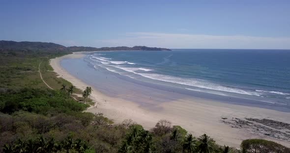 Aerial drone view of the beach, rocks and tide pools in Guiones, Nosara, Costa Rica.