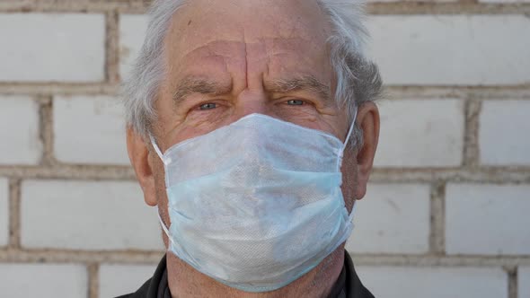 Close Up Portrait Of An Elderly Gray Haired Man In A Virus Proof Mask