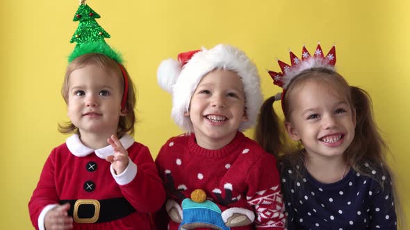 Emotion Cute Happy Cheerful 3 Siblings Friends Baby Girl And Boy in Santa Suit Smiling Laughing