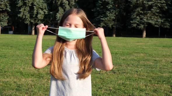 Girl Taking Off Protective Face Mask in a Park and Breathing Pure Fresh Air