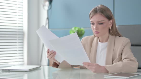 Successful Woman Celebrating While Reading Documents