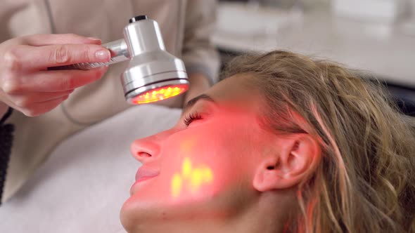 Woman which Rejuvanating Her Face Using Ultrasonic Tool which Holding Professional Beautician