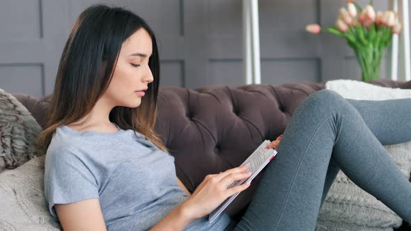 Young Woman Using Digital Tablet on Sofa