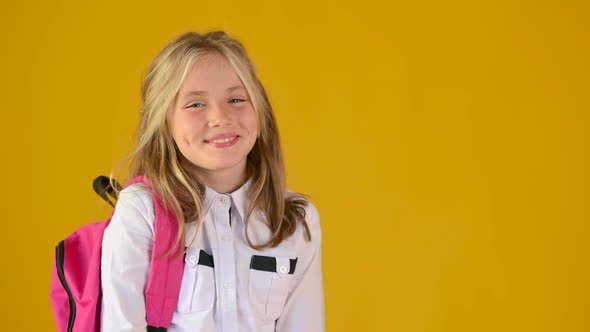 Portrait of a happy teenage schoolgirls in a school uniform with a backpack smiling