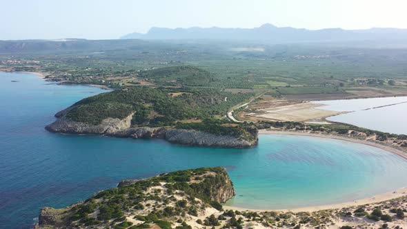 Aerial drone video of semicircular sandy beach and lagoon of Voidokilia