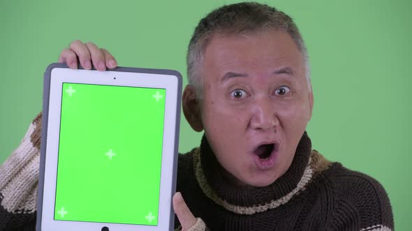 Face of Happy Mature Japanese Man Talking While Showing Digital Tablet