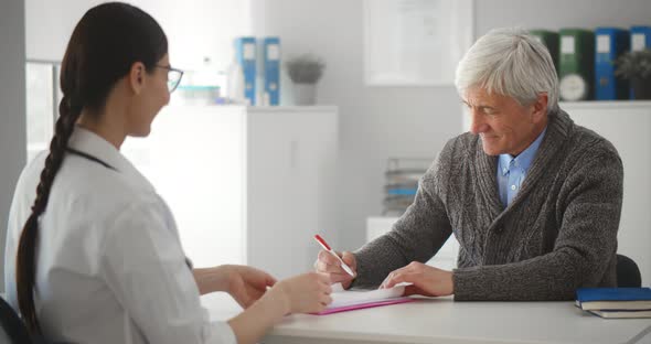 Happy Senior Patient Talking to Doctor in Hospital Office