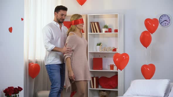 Man Leading Blindfolded With Red Ribbon Lady Into Beautifully Decorated Room