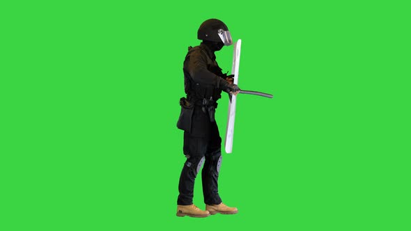 Riot Policeman Hitting Shield with the Baton While Walking on a Green Screen Chroma Key