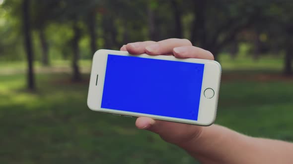 Close Up Horizontal Hands Holding Smartphone with Blue Screen