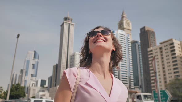 Happy Girl Walks in the Center of Dubai Against the Background of Skyscrapers