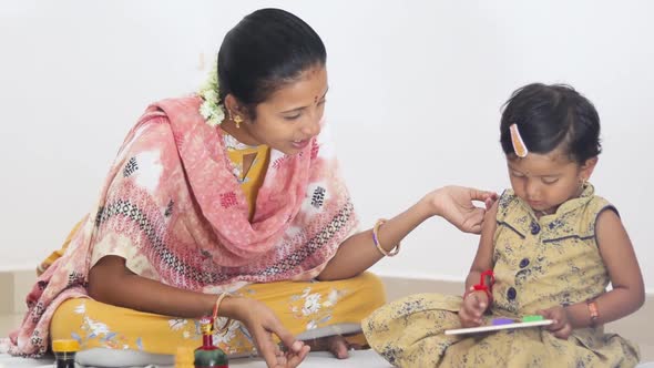 Medium Closeup shot of Indian Mother and Daughter playing with toys, Mother teaching a child how to
