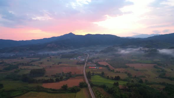 Aerial view from a drone over a misty landscape that covers the farmland